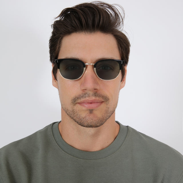 wearing Stockholm Sunglasses Black/Gold with Olive