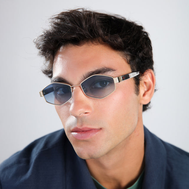Man in a navy jacket wearing Tucson Sunglasses Gold/Star Tortoise with Midnight Blue Gradient