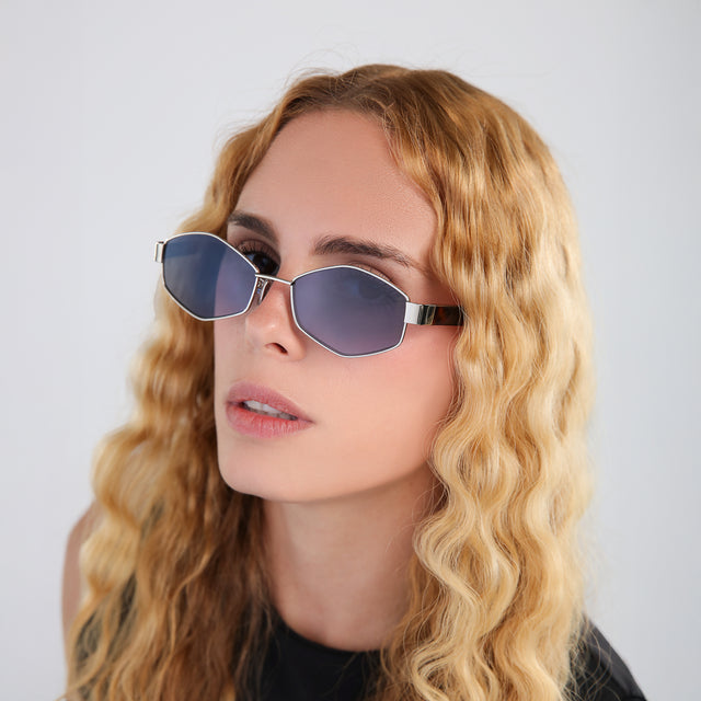 Another angle of model with blonde, wavy hair wearing Tucson Sunglasses Gold/Star Tortoise with Midnight Blue Gradient
