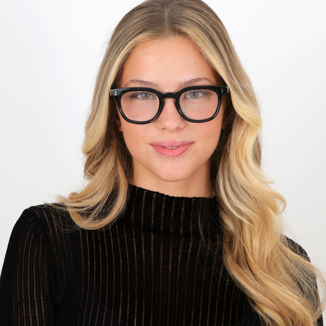 Blonde model with curled hair wearing Veneto Optical Black Optical