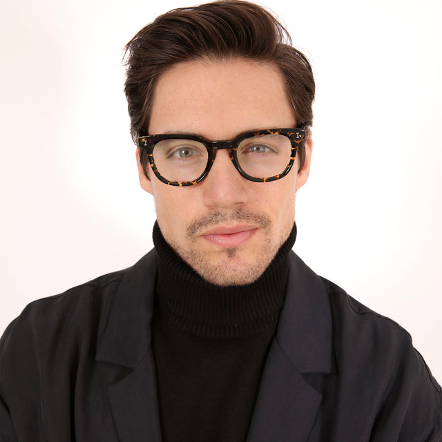 Model with short brown hair combed sideways wearing Veneto Optical Flame Optical