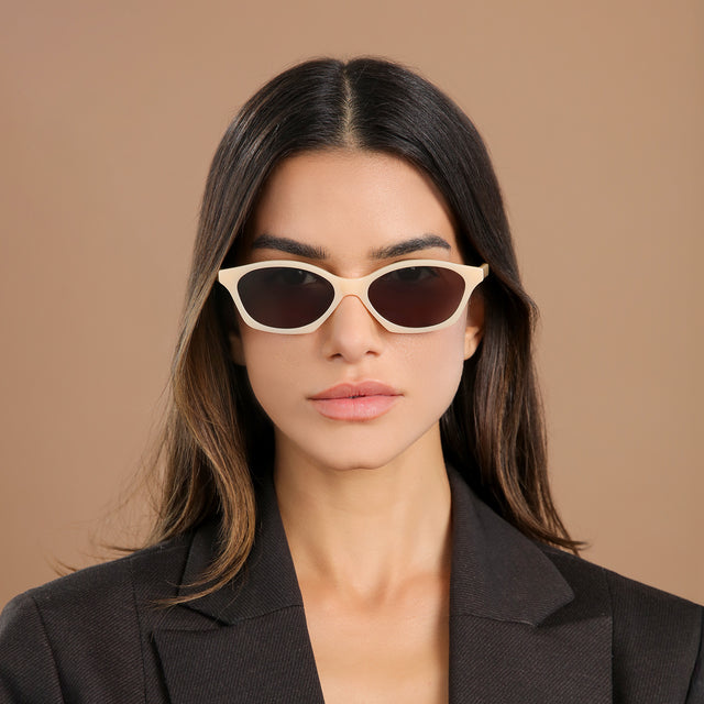 Brunette woman in a black blazer jacket wearing Vilma Sunglasses Creamsicle with Grey