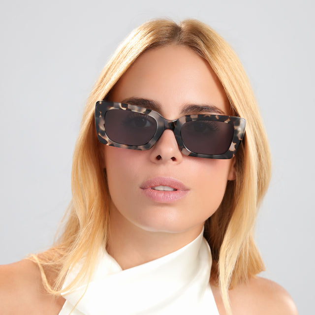 Blond woman in a silk white blouse wearing Wilson Sunglasses White Tortoise with Grey Flat