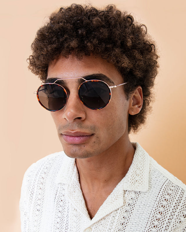 Model with afro-curly hair wearing Wynwood Ace Sunglasses Pecan/Gold with Grey Flat