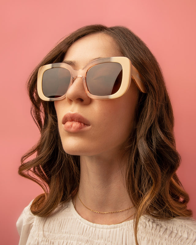 Brunette model with wavy hair wearing Anastasia Sunglasses Strawberry Cream with Brown