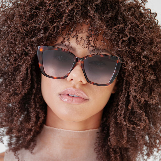 Brunette model with afro-curly hair wearing Barcelona Sunglasses Havana with Grey Flat Gradient