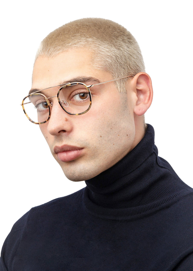 Model with blonde buzzcut wearing Corfu Optical Tortoise/Gold Optical