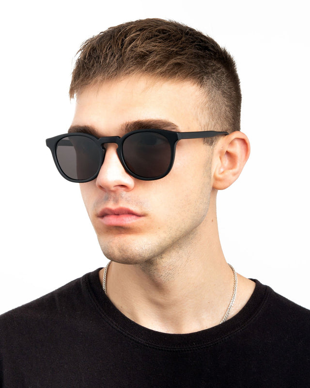 Model with short brown hair wearing Eldridge Sunglasses Matte Black with Grey Flat