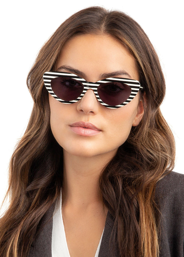 Brunette model with wavy hair wearing Pamela Sunglasses Candy Stripe with Grey Flat