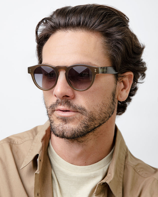 Model with short brown hair lightly combed back wearing Leonard Sunglasses Olive with Grey Gradient