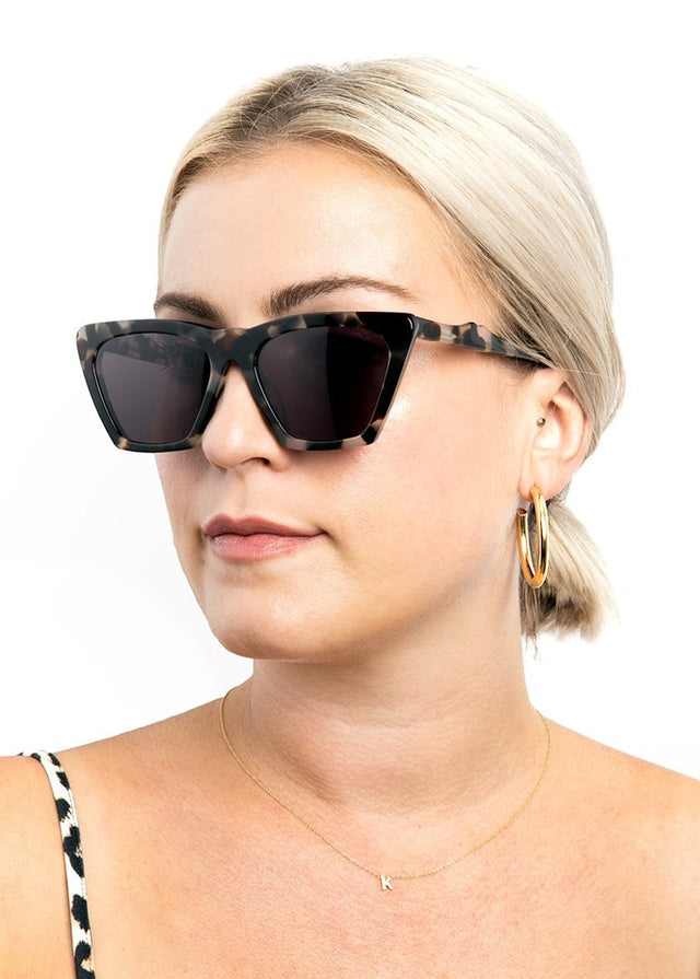 Blonde model with a low ponytail wearing Lisbon Sunglasses White Tortoise with Grey