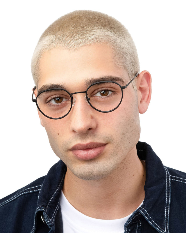 Model with blonde buzzcut wearing Oxford Optical Matte Black Optical