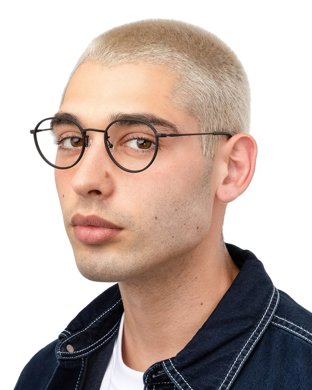 Angled pose of model with blonde buzzcut wearing Oxford Optical Matte Black Optical