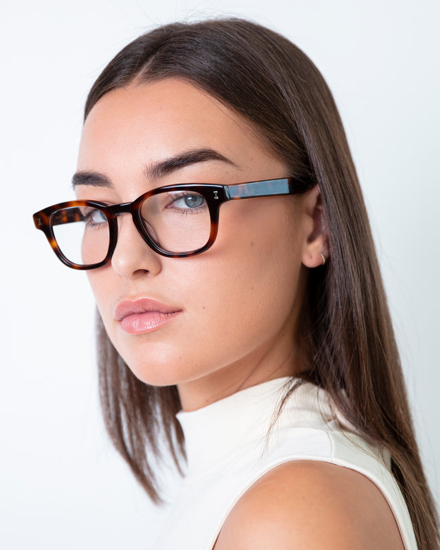 Brunette model with straight hair wearing Pacific Optical Havana Optical