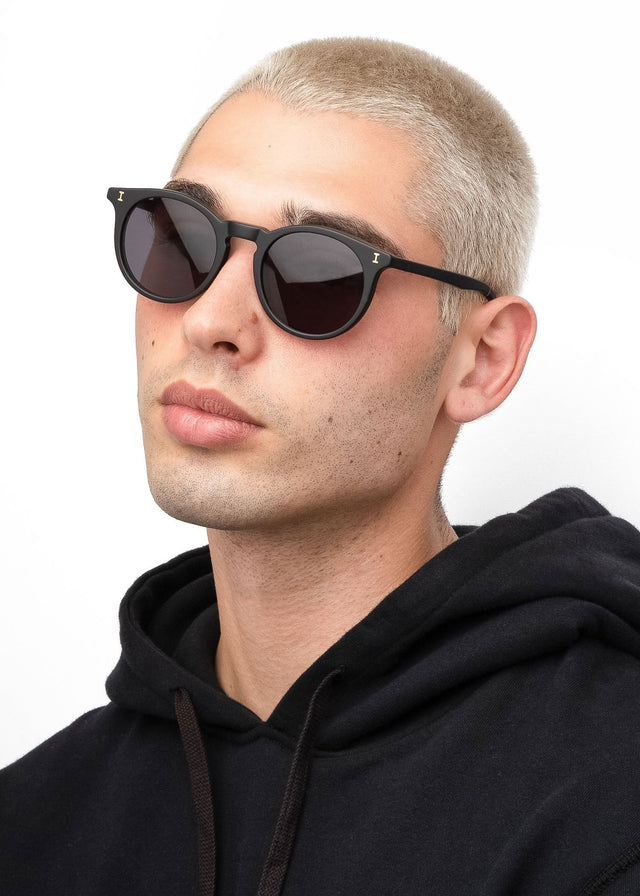 Model with blonde buzzcut wearing Sterling Sunglasses Matte Black with Grey Flat