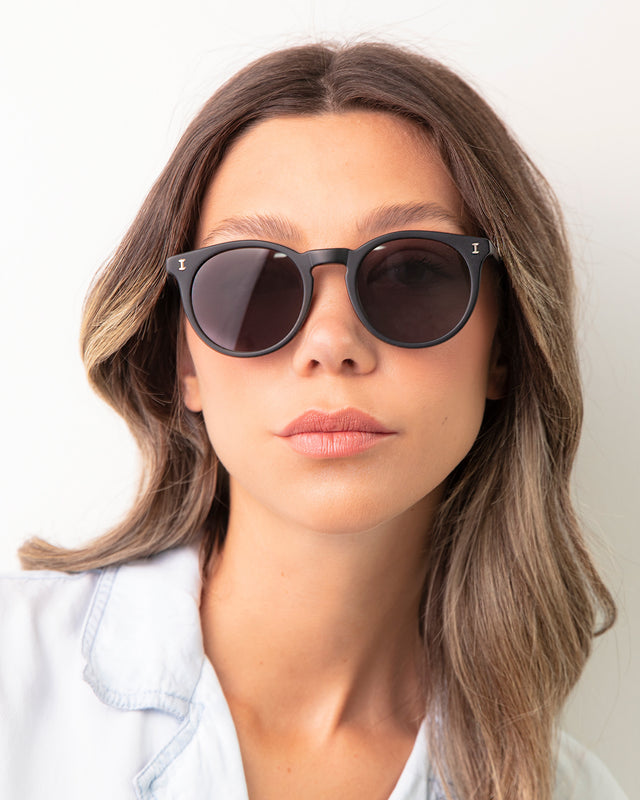 Brunette model with ombre wavy hair wearing Sterling Sunglasses Matte Black with Grey Flat