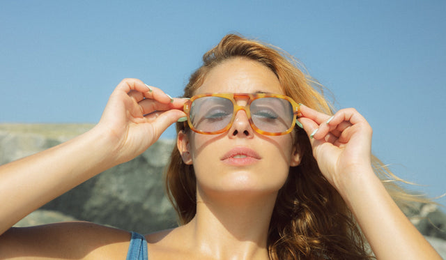 Woman at the beach wearing Memphis in Amber with Light Blue lenses