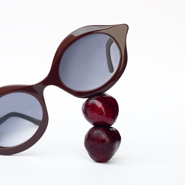 The Willow Sunglasses in Bordeaux displayed with cherries