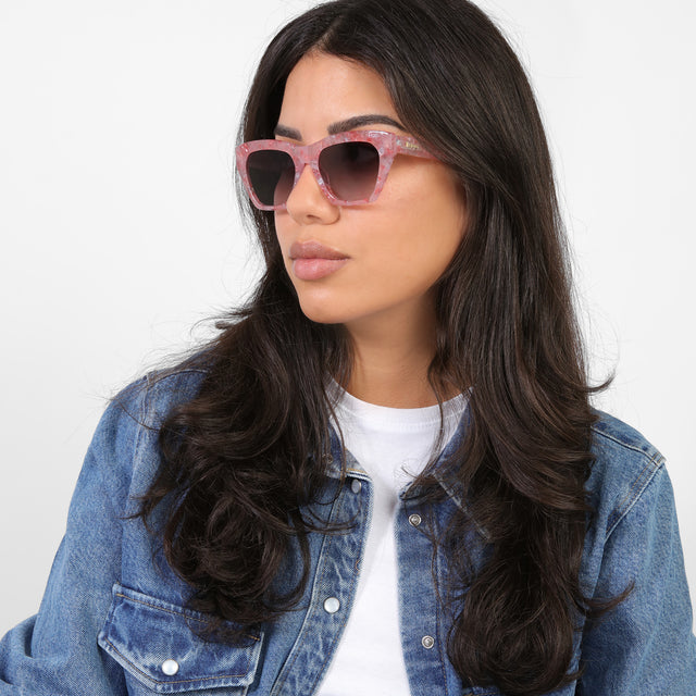 Brunette model in a denim jacket looking right wearing Bali Sunglasses Rose Quartz with Grey Gradient