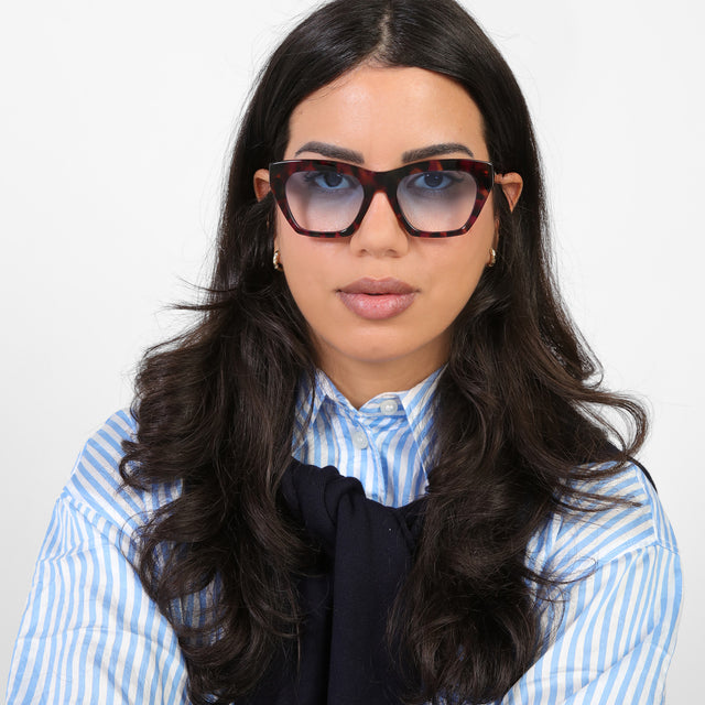 Brunette model in a blue and white striped blouse wearing Bali Sunglasses Violet Havana with Blue Gradient See Through