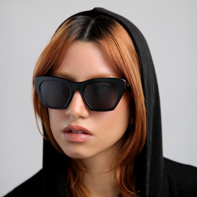 Red-haired model looking to her right wearing Bali Sunglasses Black with Grey