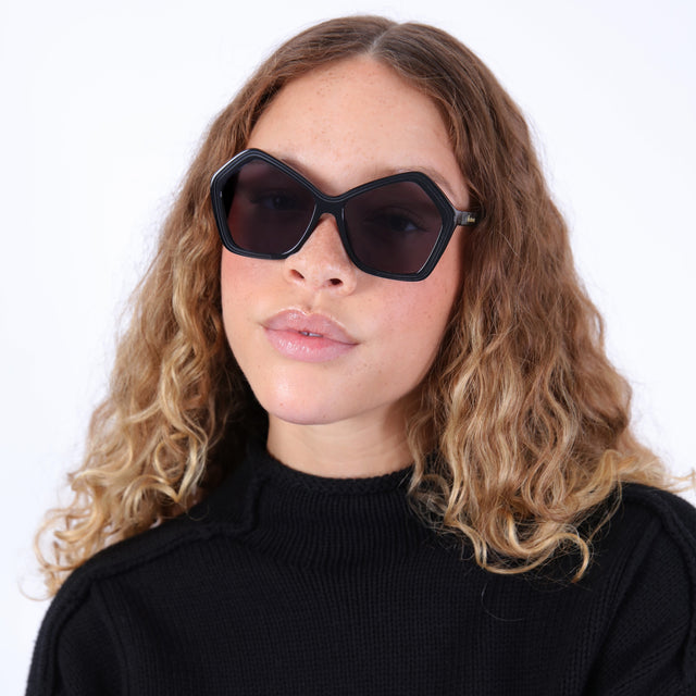 Brunette model with ombré, wavy hair wearing Barbra 55 Sunglasses Black with Grey Flat