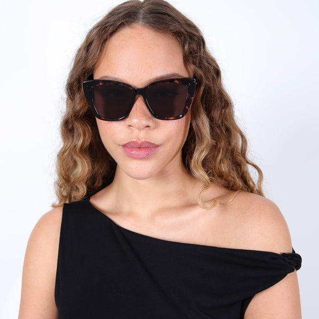 Brunette model with ombré, wavy hair wearing Barcelona Sunglasses Sundae with Grey Flat