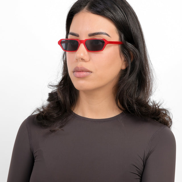 Brunette model with loose curls wearing Baxter Sunglasses Red with Grey