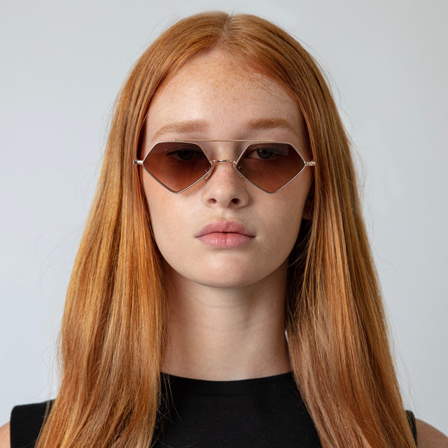 Model with long red hair wearing Bayley Sunglasses Rose Gold with Brown Flat Gradient