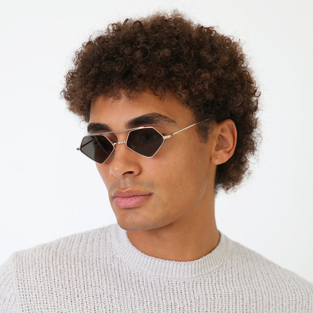 Model with afro-curly hair wearing Bayley Sunglasses Silver with Olive Flat