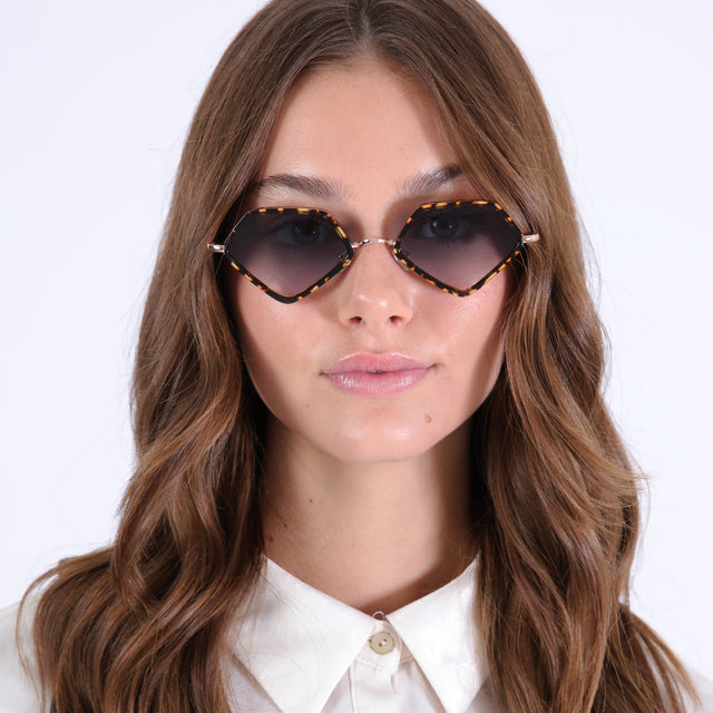 Brunette model with curled hair wearing Beak Ace 53 Sunglasses Flame/Rose Gold with Grey Flat Gradient