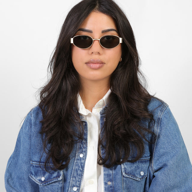 Brunette model in a denim jacket wearing Bellagio Sunglasses Brushed Gold with Grey