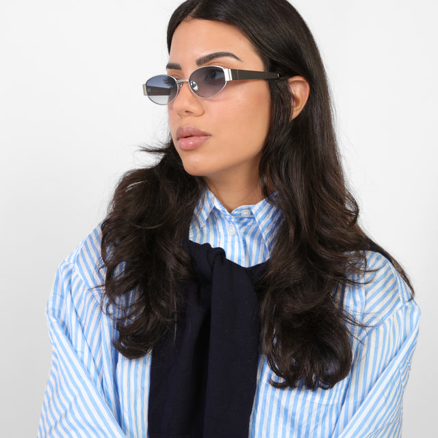 Brunette model in a blue and white striped blouse looking right wearing Bellagio Sunglasses Brushed Silver with Midnight Blue Gradient