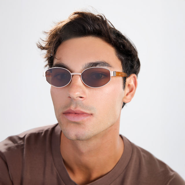 Another angle of man with brown hair in a brown shirt wearing Bellagio A Sunglasses Rose Gold/Honey Gold with Brown