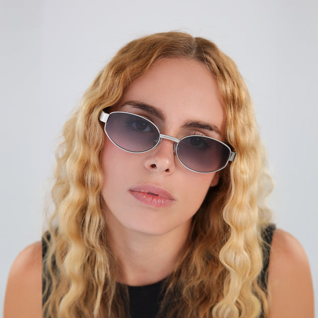 Blond woman with wavy hair in a black blouse wearing Bellagio A Sunglasses Silver/Havana with Grey Gradient