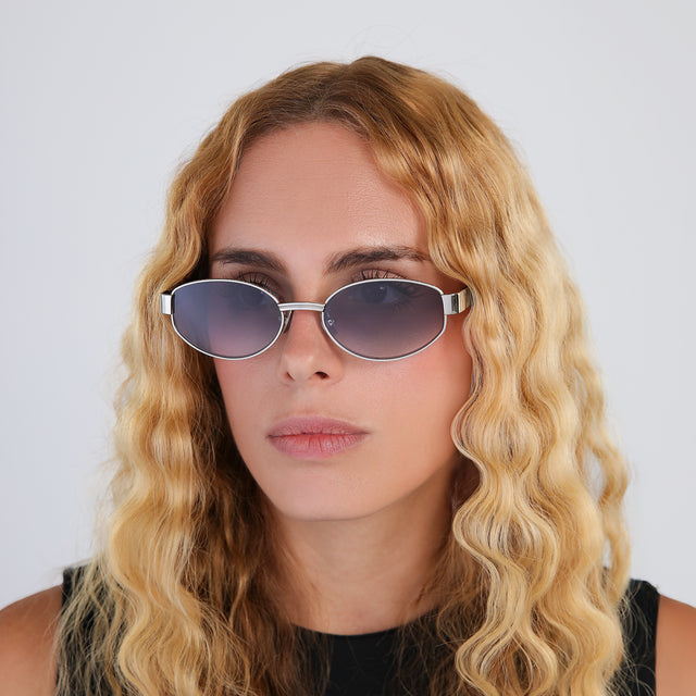 Close up of blond woman with wavy hair in a black blouse wearing Bellagio A Sunglasses Silver/Havana with Grey Gradient