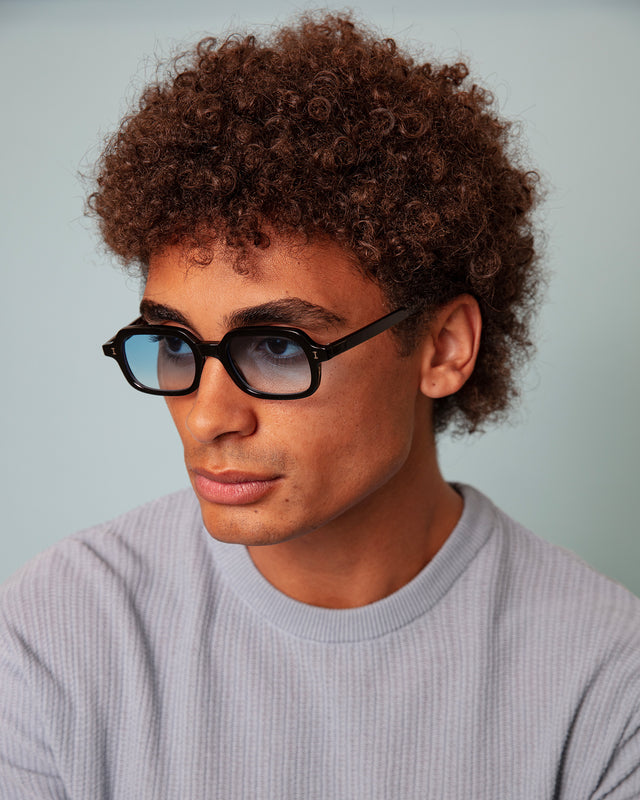 Model with afro-curly hair wearing Berlin Sunglasses Black with Blue Gradient See Through