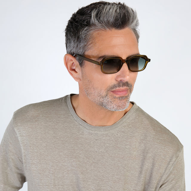 Model with salt and pepper hair and beard wearing Berlin Sunglasses Moss with Olive Gradient