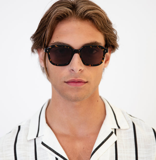 Model with semi short brown hair in a striped linen shirt wearing Bogota Sunglasses Flame with Brown Flat