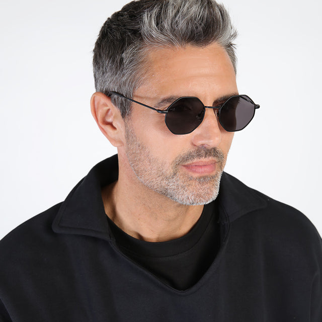 Model with salt and pepper hair and beard looking left wearing Broome Sunglasses Matte Black with Grey Flat