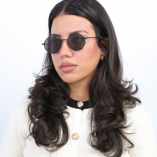 Brunette model with curls wearing Broome Sunglasses Matte Black with Grey Flat