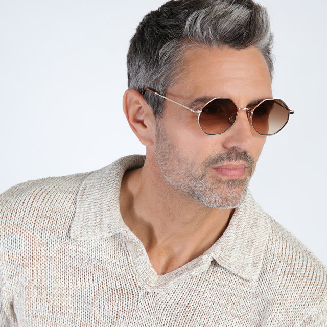 Model with salt and pepper hair and beard looking left wearing Broome Sunglasses Rose Gold with Brown Flat Gradient