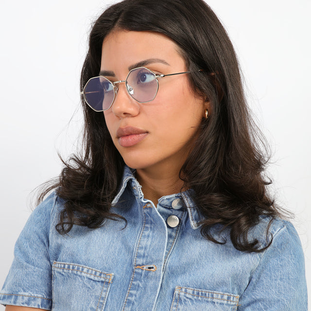 Brunette model with curls looking right wearing Broome Sunglasses  Silver with Light Blue Flat See Through