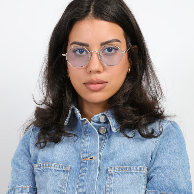 Brunette model with curls wearing Broome Sunglasses Silver with Light Blue Flat See Through