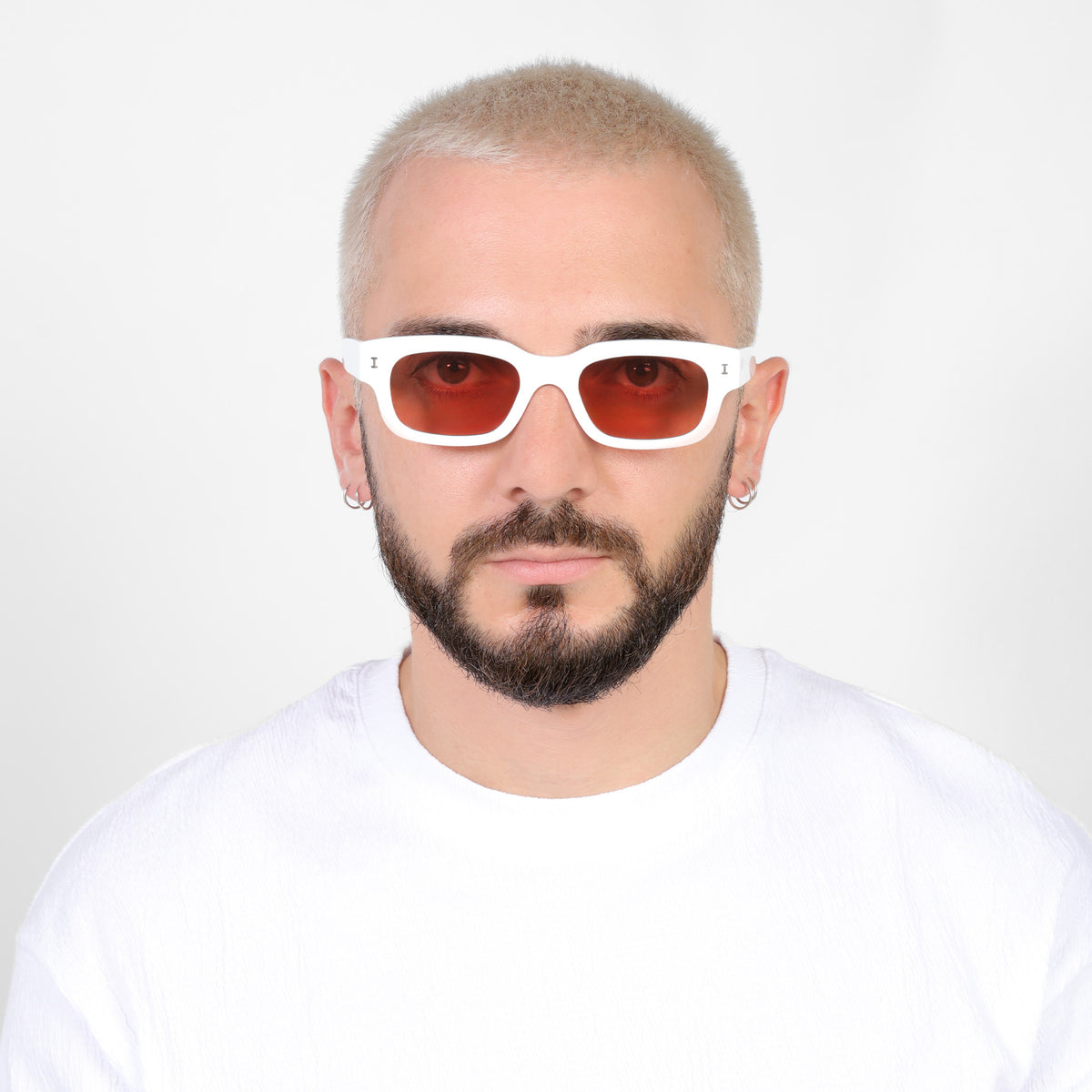 Man wearing Cali E Sunglasses in White with Guava See Through lenses, Model with a platinum buzzcut