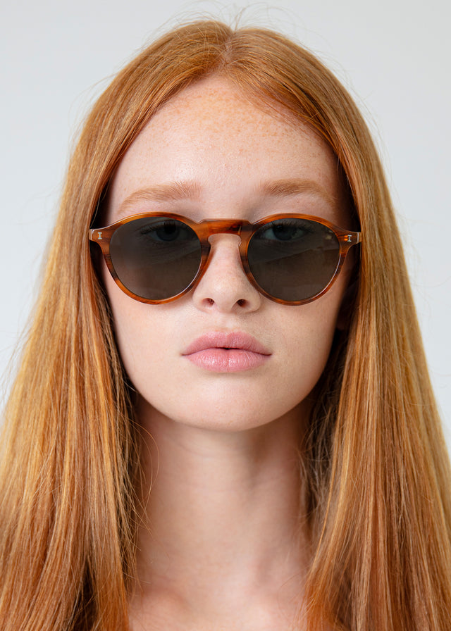 Woman with red hair wearing Capri Sunglasses Teak with Olive