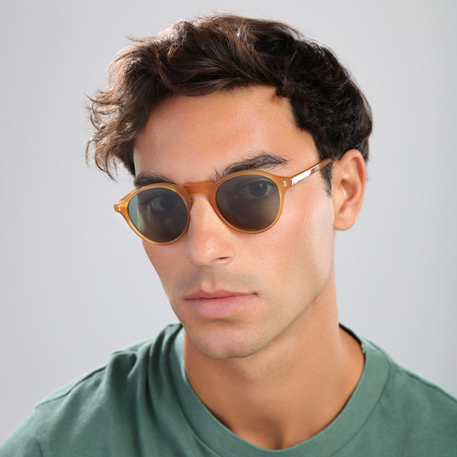 Man with brown hair in a green tee wearing Capri Sunglasses Honey with Olive