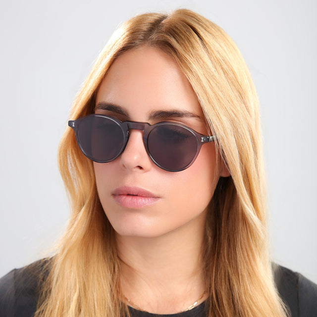 Blond woman in black tee wearing Capri Sunglasses Mercury with Grey