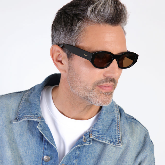 Model with salt and pepper hair and beard looking left wearing Cassette Sunglasses Black with Brown Flat