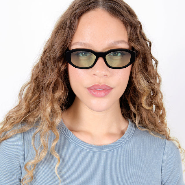 Brunette model with ombré, natural curls wearing Cassette Sunglasses Black with Mint Flat See Through